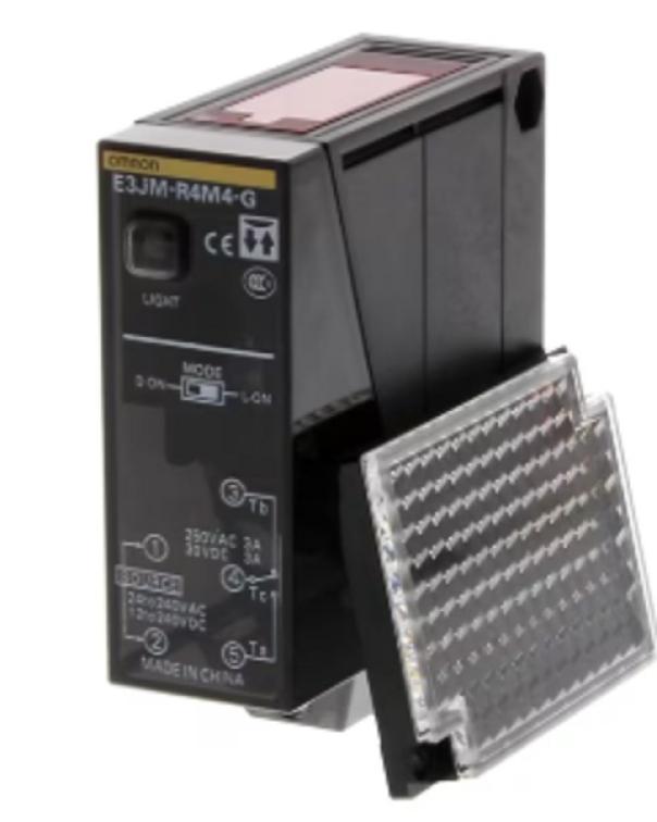 sensore fotoelettrico retroriflettente Omron E3JMR4M4G con catarifrangente in primo piano su sfondo bianco